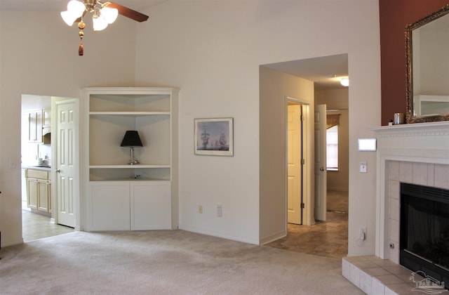 unfurnished living room featuring light colored carpet, baseboards, a ceiling fan, and a fireplace