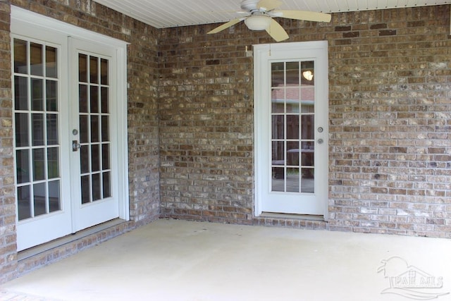 property entrance featuring a ceiling fan, french doors, brick siding, and a patio