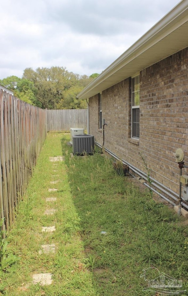 view of yard with central AC and a fenced backyard