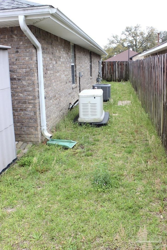 view of yard featuring central air condition unit and fence