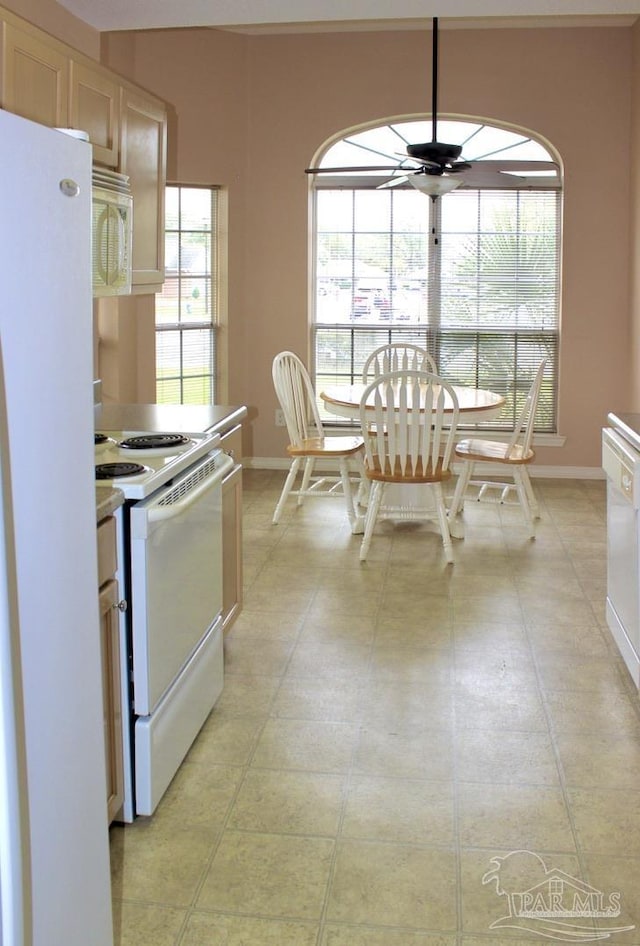 kitchen with baseboards, a ceiling fan, white appliances, and light countertops