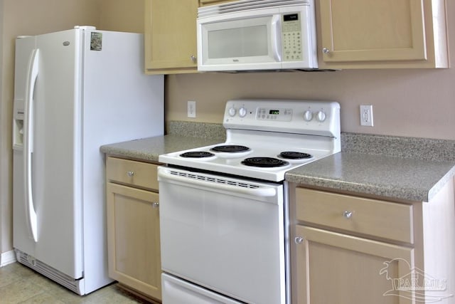 kitchen featuring light countertops, light brown cabinets, and white appliances