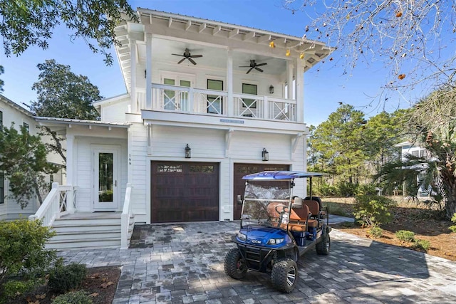 view of front of property with ceiling fan, a balcony, and a garage