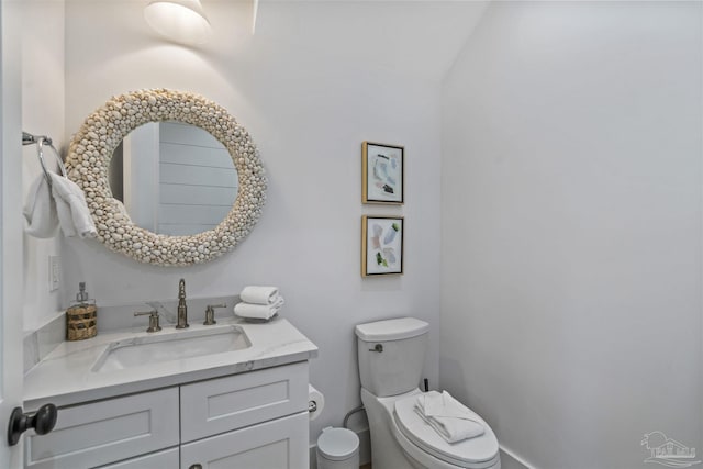 bathroom with vanity, vaulted ceiling, and toilet