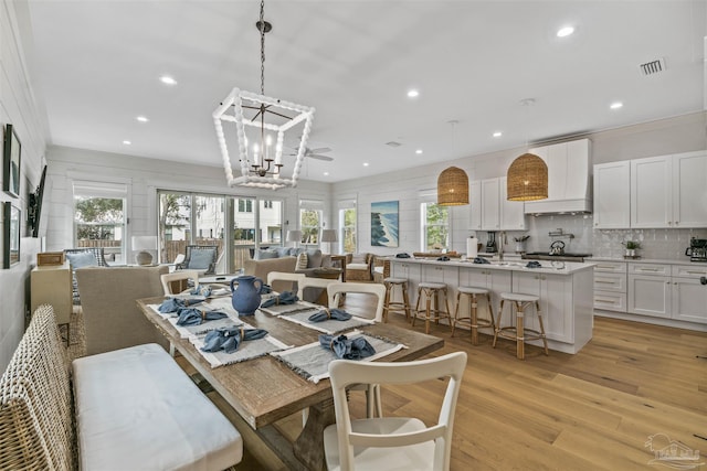 dining room with a chandelier, light hardwood / wood-style flooring, and ornamental molding