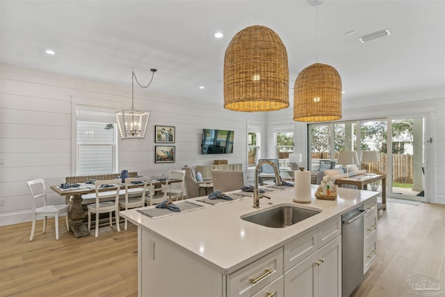 kitchen with pendant lighting, a center island with sink, and light hardwood / wood-style floors