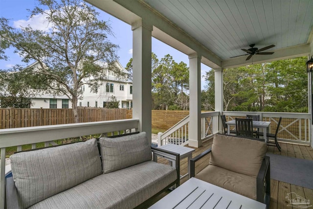 wooden deck with ceiling fan and an outdoor living space