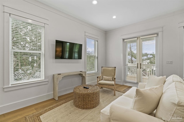 sitting room featuring french doors, ornamental molding, and hardwood / wood-style flooring