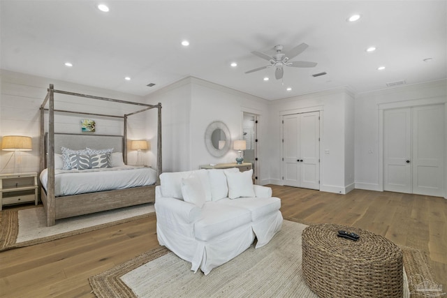 bedroom featuring light hardwood / wood-style floors, ceiling fan, and ornamental molding