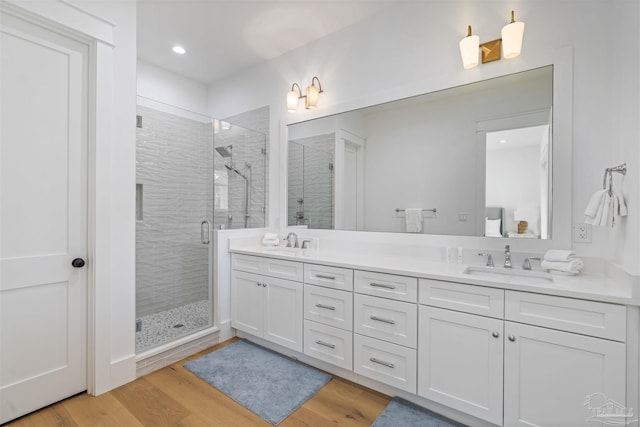 bathroom with vanity, wood-type flooring, and a shower with shower door