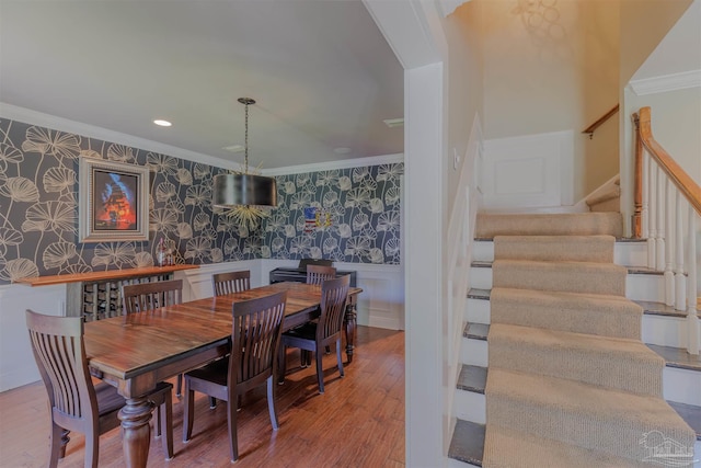 334 Andrew Jackson Trl, Gulf Breeze, FL 32561 - dining room featuring wallpapered walls, crown molding, stairway, wainscoting, and wood finished floors