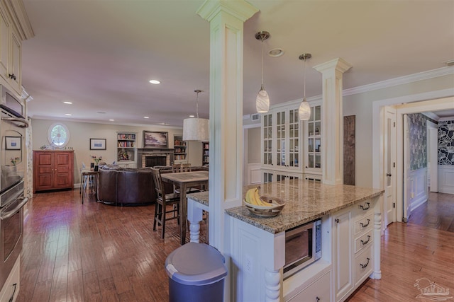 334 Andrew Jackson Trl, Gulf Breeze, FL 32561 - kitchen with ornate columns, stainless steel microwave, hardwood / wood-style floors, ornamental molding, and recessed lighting
