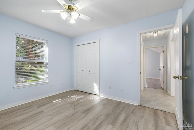 unfurnished bedroom with ceiling fan, a closet, and light wood-type flooring