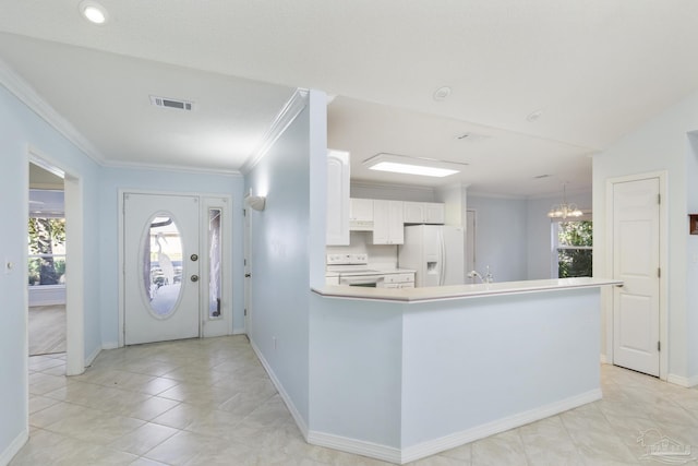 kitchen featuring kitchen peninsula, ornamental molding, white appliances, an inviting chandelier, and white cabinetry