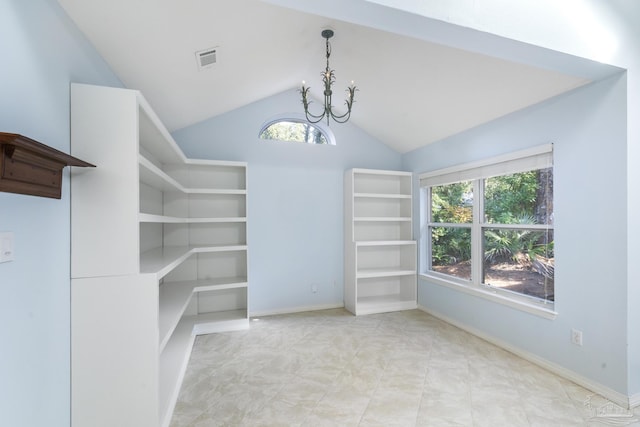 walk in closet with high vaulted ceiling and an inviting chandelier