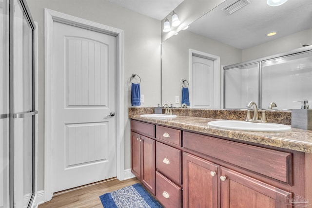 3818 Weatherstone Cir, Pensacola, FL 32507 - bathroom with double vanity, a stall shower, and wood finished floors