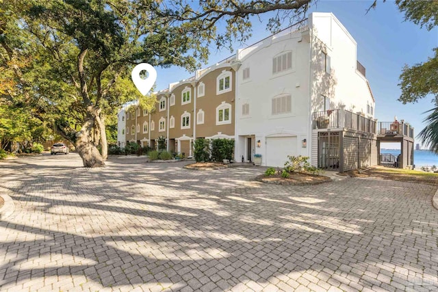 view of property with decorative driveway and an attached garage