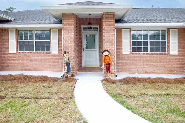 view of exterior entry featuring a yard