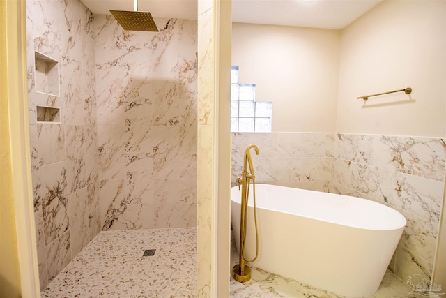 bathroom featuring shower with separate bathtub and tile walls