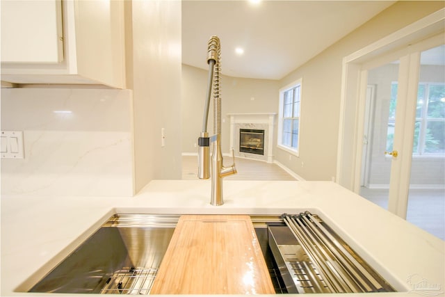 room details featuring a premium fireplace, decorative light fixtures, wooden counters, and white cabinets