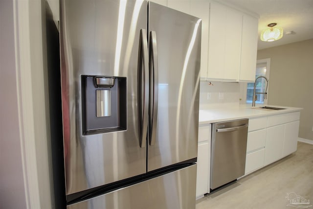 kitchen featuring light wood-type flooring, white cabinetry, sink, and stainless steel appliances