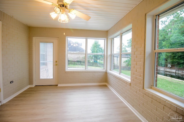 unfurnished sunroom with ceiling fan and a wealth of natural light