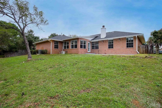 back of house featuring a lawn and cooling unit