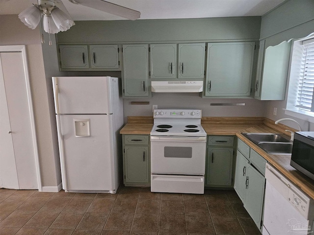 kitchen with a sink, range hood, white appliances, light countertops, and ceiling fan