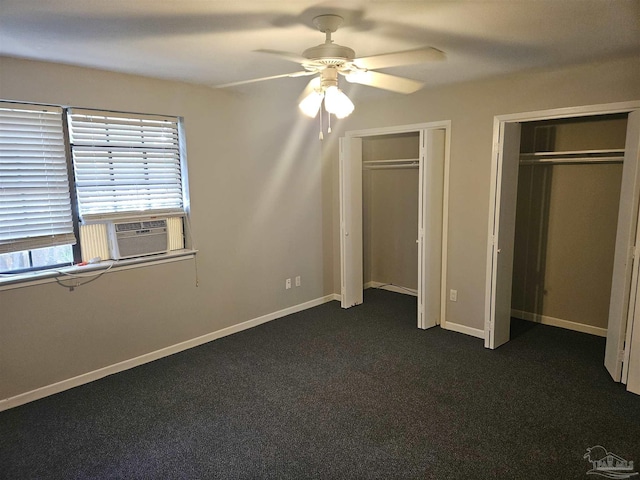 unfurnished bedroom featuring a ceiling fan, baseboards, multiple closets, and dark carpet