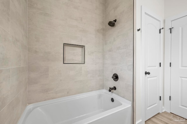 bathroom featuring tiled shower / bath combo and wood-type flooring