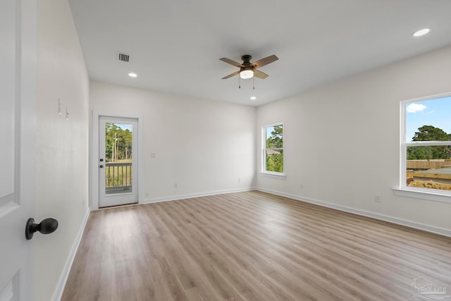 spare room featuring light hardwood / wood-style flooring, ceiling fan, and a wealth of natural light