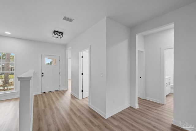 entrance foyer with light wood-style floors, baseboards, and visible vents