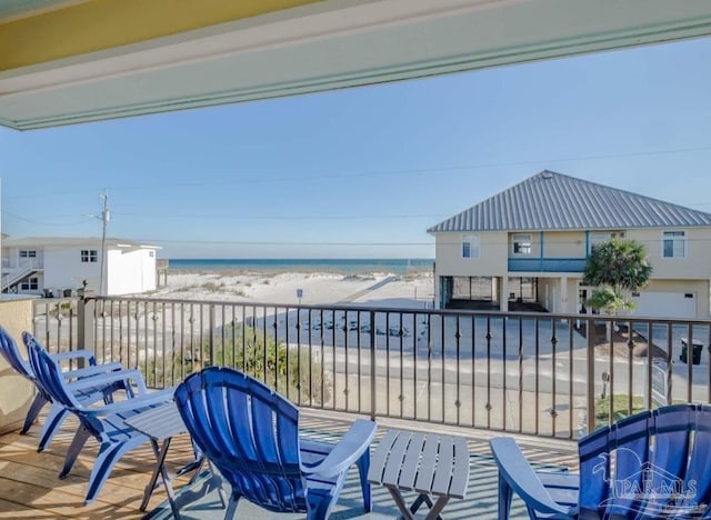 balcony with a water view and a view of the beach