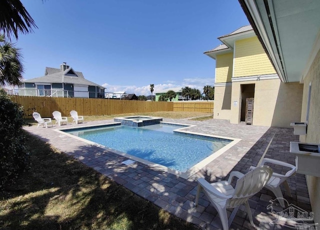 view of swimming pool featuring a patio area and an in ground hot tub