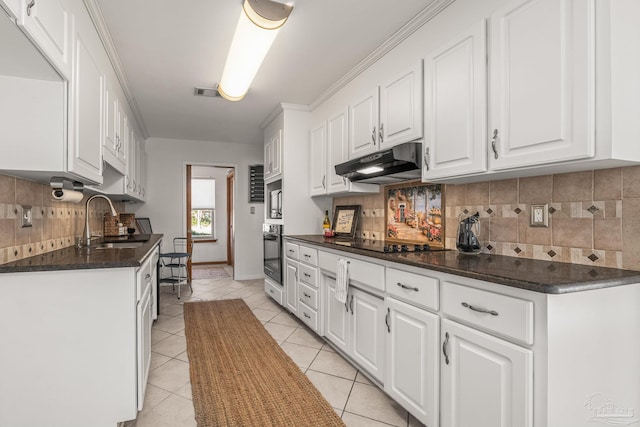 kitchen with black appliances, sink, light tile patterned floors, dark stone counters, and white cabinets