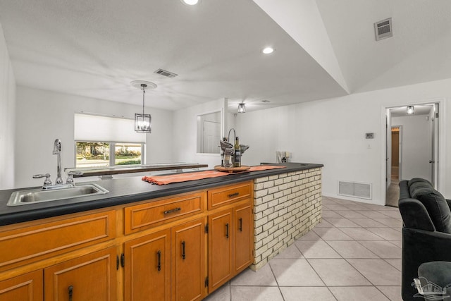 kitchen with light tile patterned floors, sink, and pendant lighting