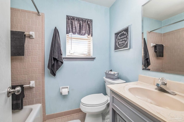 full bathroom with tiled shower / bath combo, vanity, tile patterned flooring, and toilet