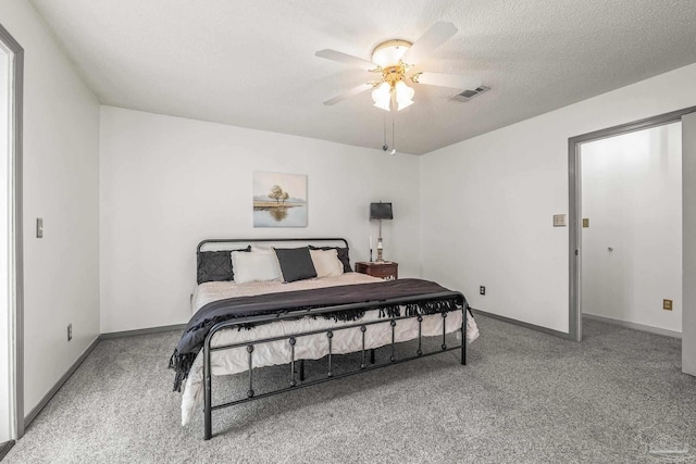 bedroom with carpet, ceiling fan, and a textured ceiling