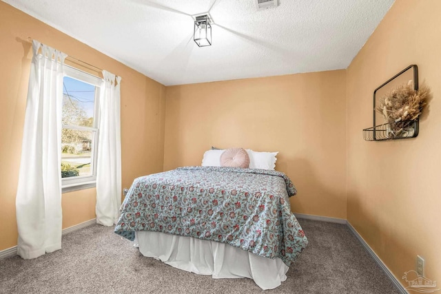 bedroom with carpet floors and a textured ceiling