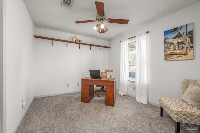 office featuring a textured ceiling, light colored carpet, and ceiling fan