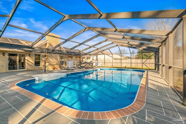 view of swimming pool featuring a lanai and a patio area