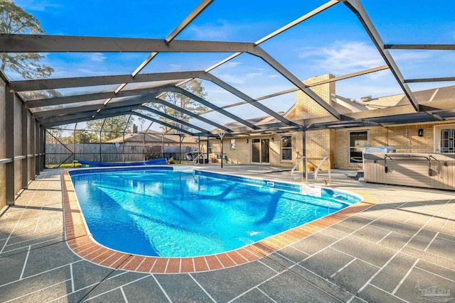 view of swimming pool with a patio, a lanai, and a hot tub