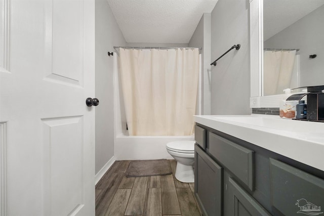 full bathroom with hardwood / wood-style flooring, a textured ceiling, shower / tub combo with curtain, vanity, and toilet