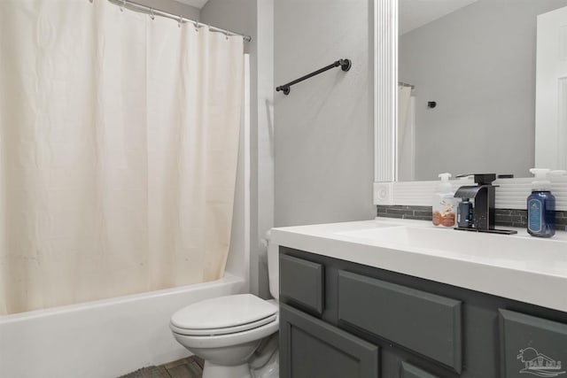 full bathroom featuring shower / bath combo, vanity, and toilet