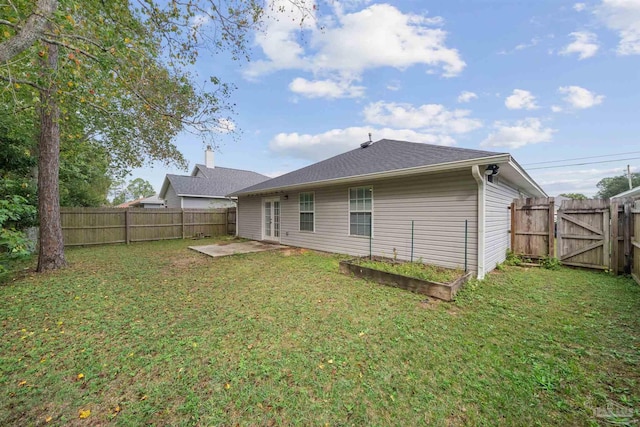 rear view of house featuring a lawn and a patio