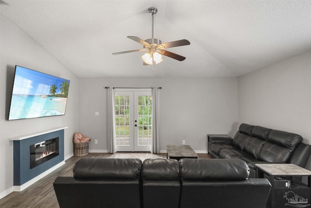 living room featuring ceiling fan, a textured ceiling, lofted ceiling, dark wood-type flooring, and french doors