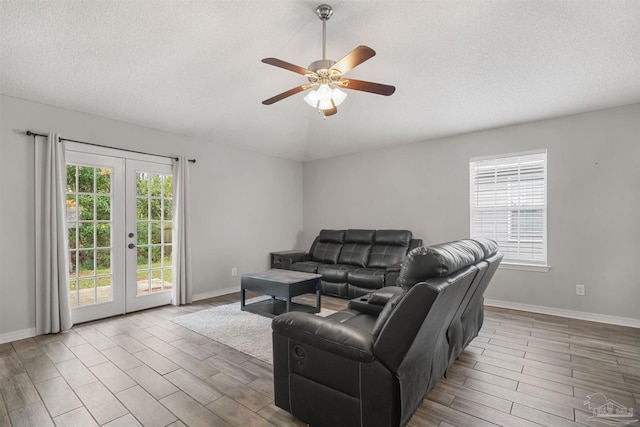 living room featuring a textured ceiling, french doors, hardwood / wood-style flooring, and ceiling fan