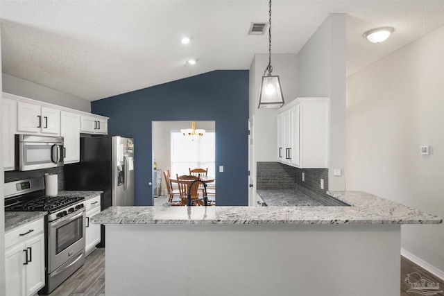 kitchen with white cabinets, kitchen peninsula, backsplash, appliances with stainless steel finishes, and decorative light fixtures