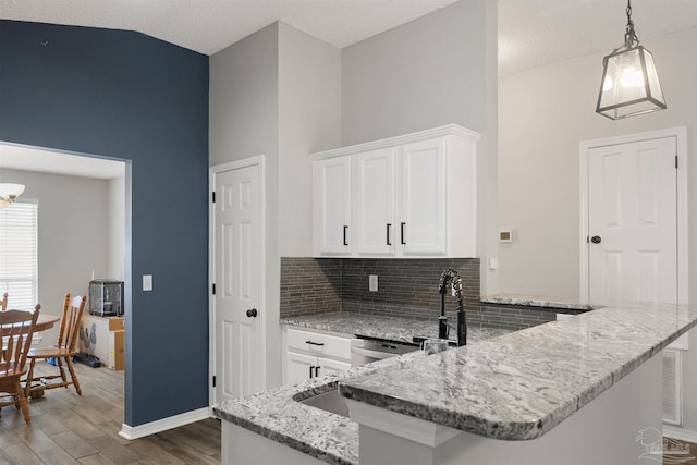 kitchen featuring dark hardwood / wood-style floors, white cabinetry, decorative light fixtures, and a textured ceiling