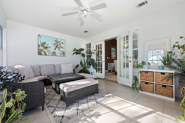 living room featuring light tile patterned floors, ceiling fan, and french doors